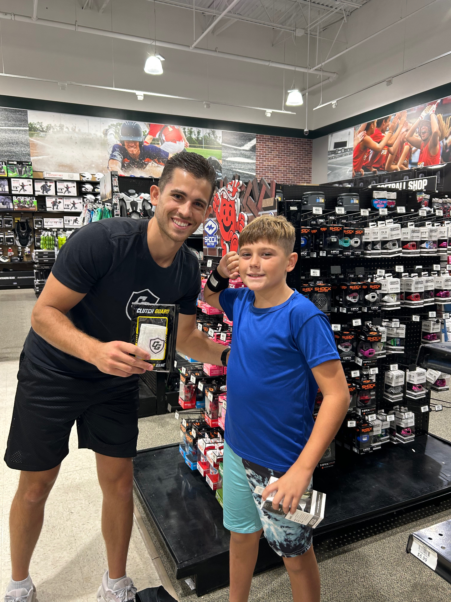 Clutch Guard founder with a young athlete in a blue shirt wearing a Clutch Guard wristband